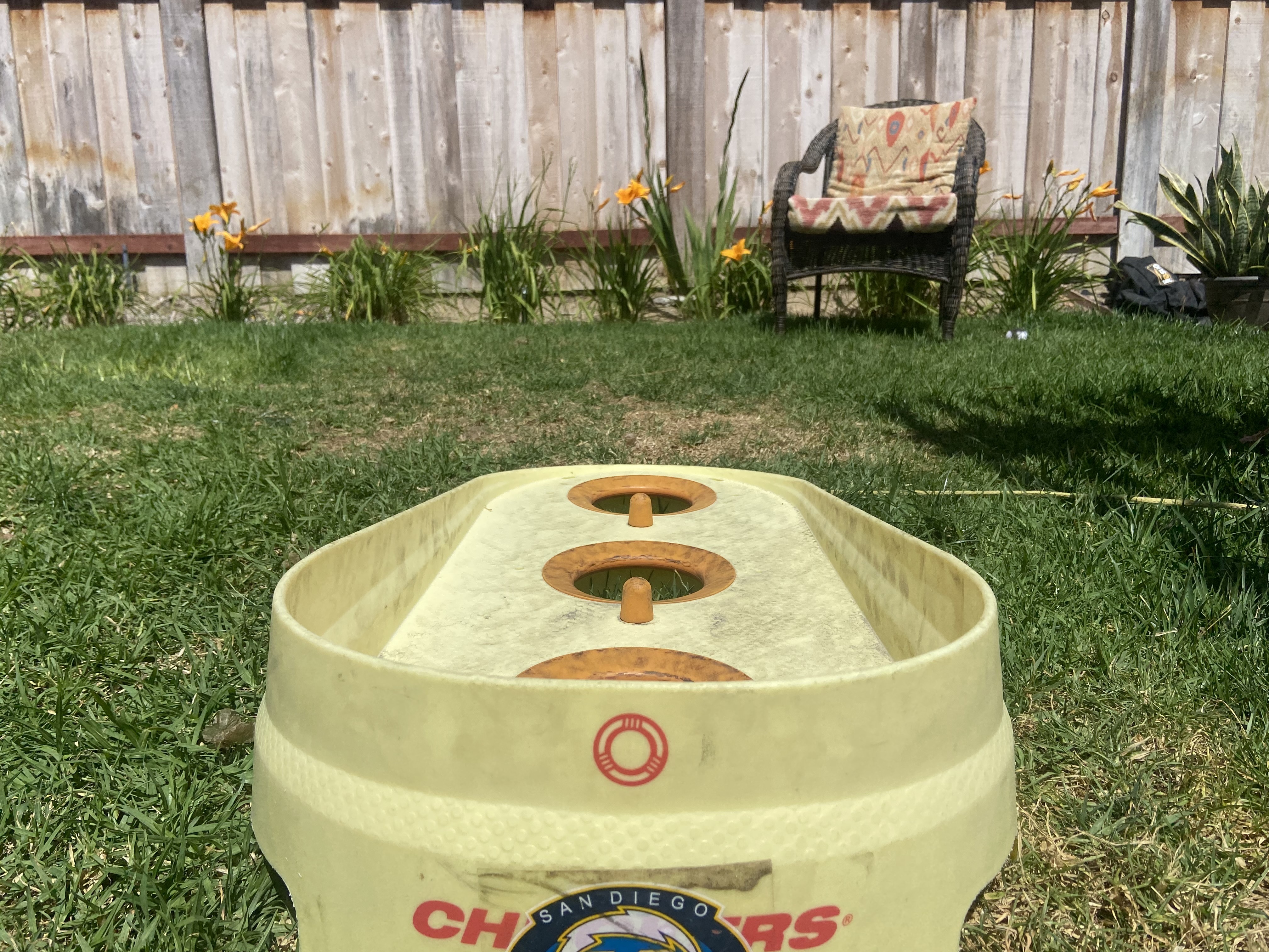 A Chuckers board set up in the backyard grass, ready for a game.